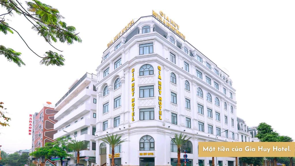 Ðông KhêGia Huy Hotel的白色的建筑,旁边标有标志
