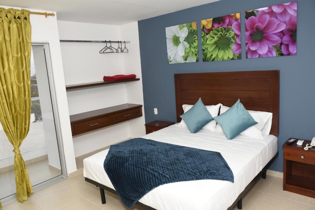 SoledadHotel Kai Soledad Atlántico的一间卧室配有一张带蓝色墙壁和镜子的床