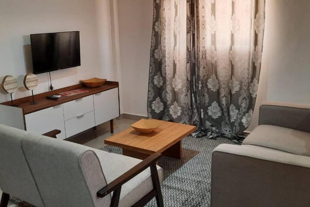 罗安达28A, Lumir Apartamento #8, Luanda的带沙发、电视和桌子的客厅