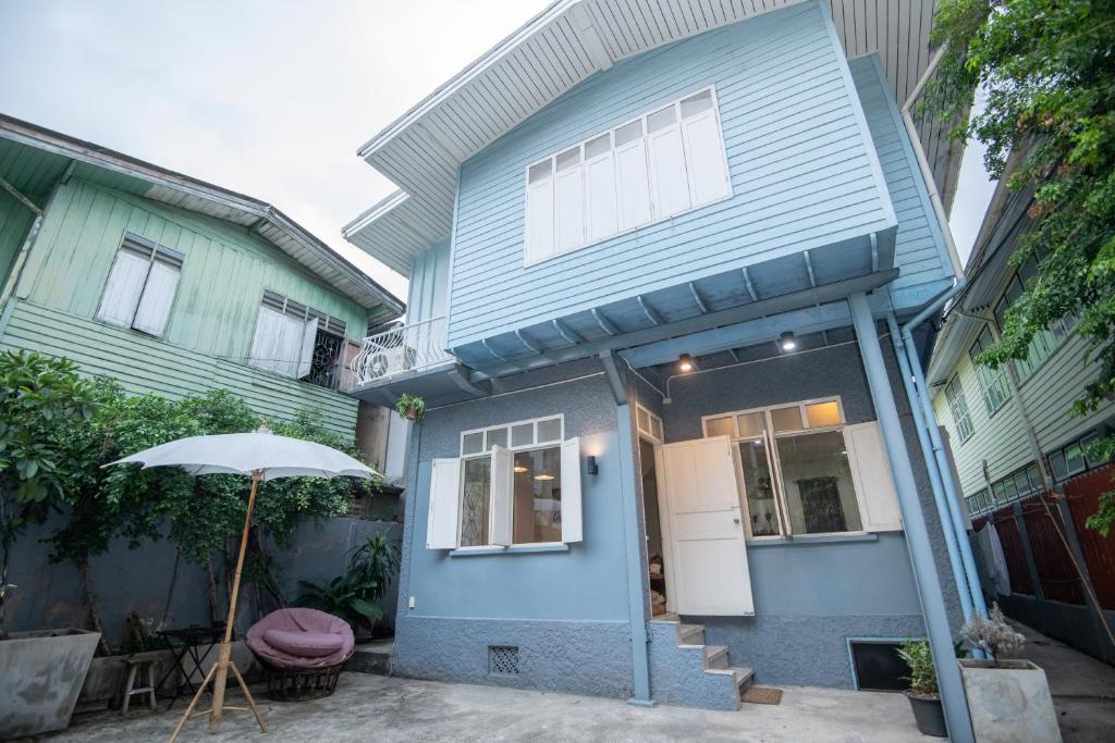 曼谷Dara Three Hostel ดาราตรี的前面有一把伞的蓝色房子