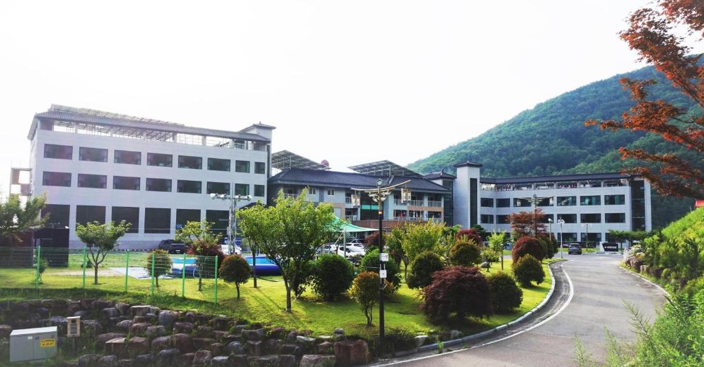SancheongSancheong Korean Medicine Family Hotel的山前有墓地的建筑物