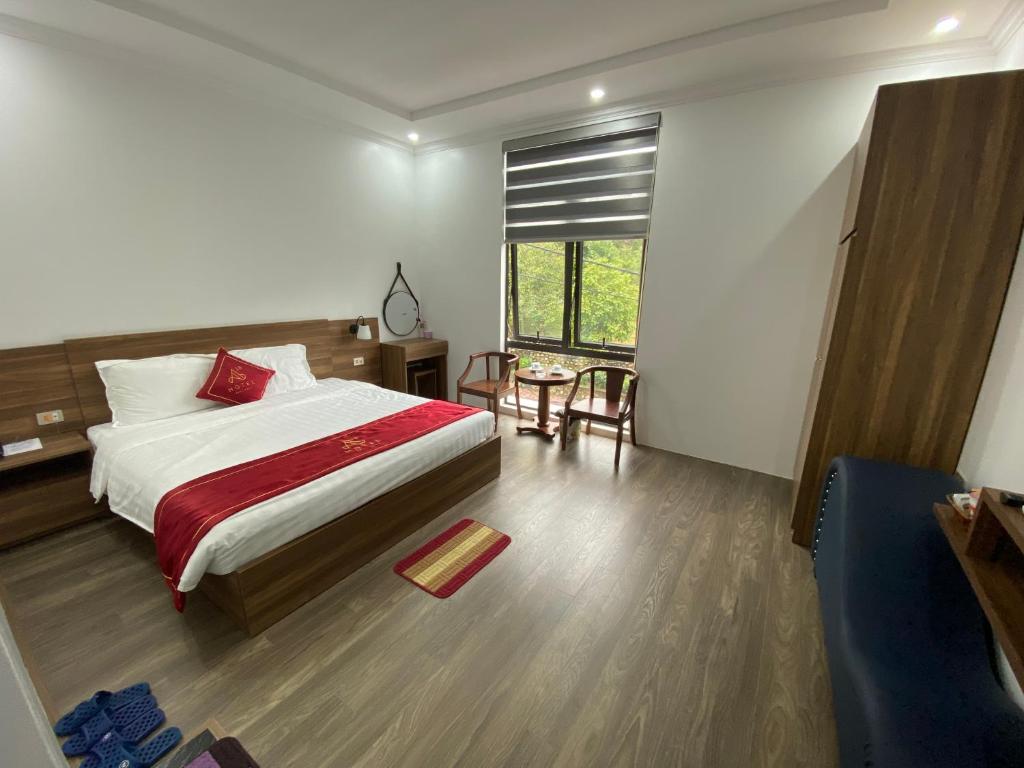 老街市Hotel A18 Lào Cai的一间卧室配有一张床、一张桌子和一个窗户。