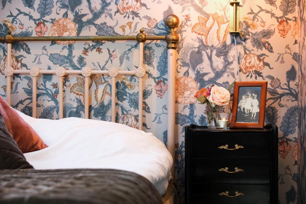 吕瑟希尔Strandvillan Hotell och Bed & Breakfast的一间卧室配有一张床和花卉壁纸