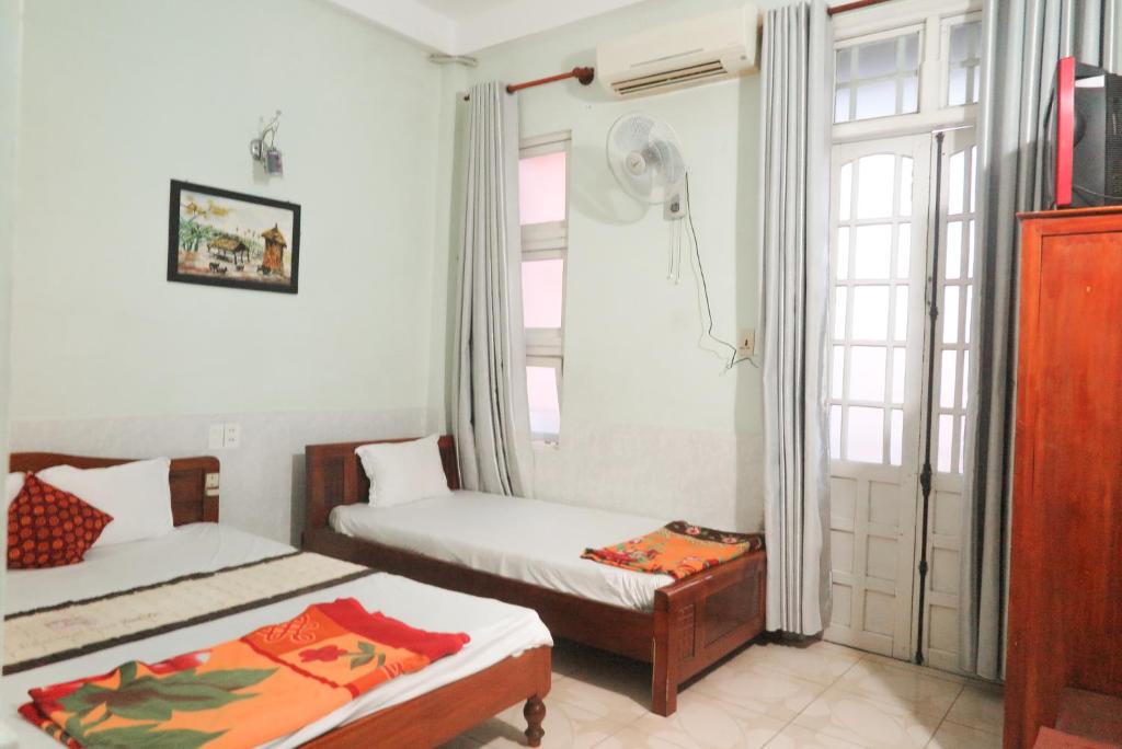 顺化Binh An Hostel的一间卧室设有两张床和窗户。