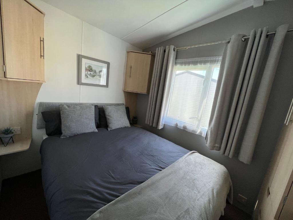 新米尔顿Forest & beach access Naish park的一间小卧室,配有床和窗户