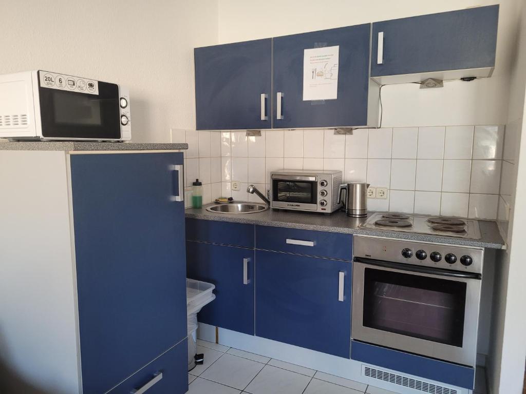 德累斯顿Mickten Hertz的厨房配有蓝色橱柜和微波炉
