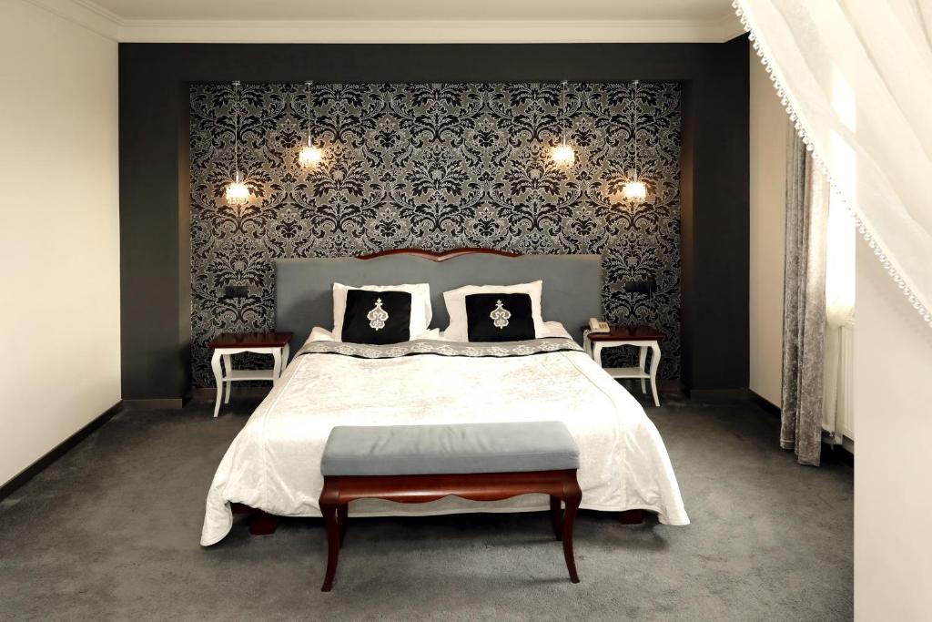 波兹南Biały Dom Henlex Hotel Restauracja的一间卧室设有一张大床和黑色墙壁