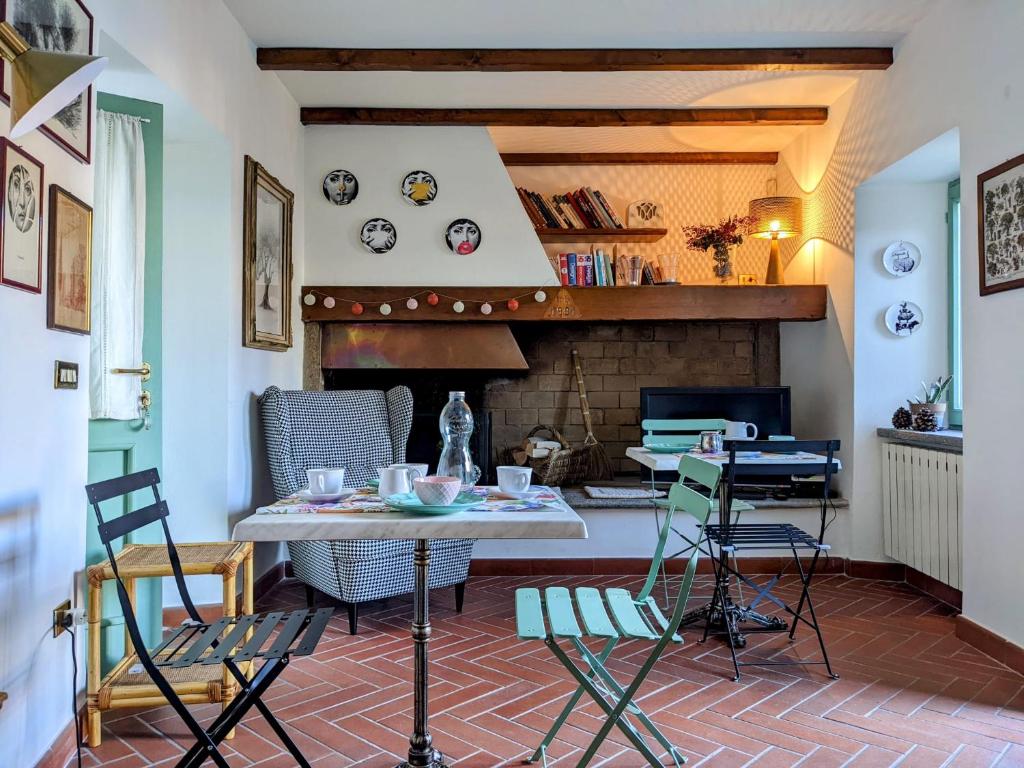 斯特雷萨B&B Il Poggiolo的客厅配有桌椅和壁炉