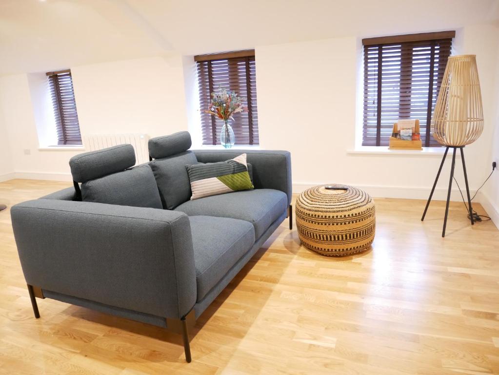 阿尔弗斯顿Scandic Apartment, Ulverston的客厅设有蓝色的沙发和木地板