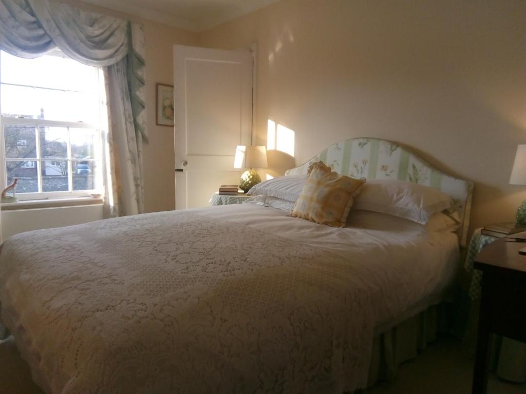 费克纳姆The Dower House的卧室配有白色的床和窗户。