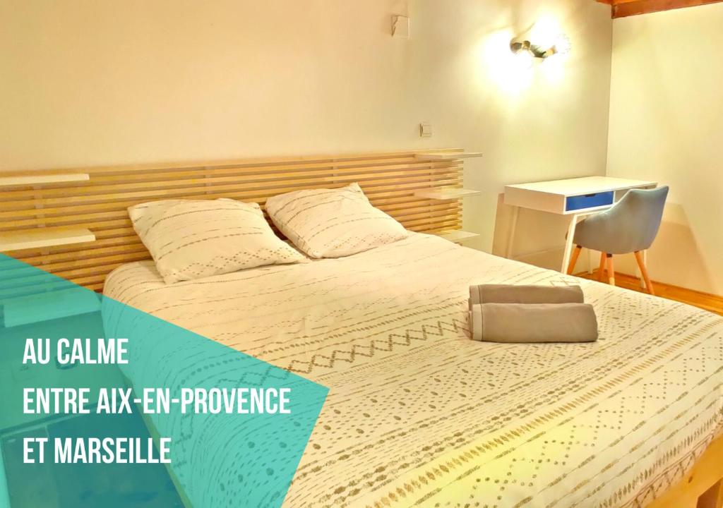 AuriolENTRE AIX ET MARSEILLE - Petite maison à Auriol的一间卧室配有一张大床、椅子和一张书桌