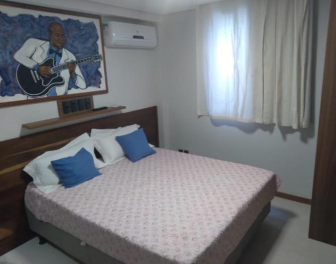 萨尔瓦多Hospedaria D'Maria的一间卧室配有一张带蓝色枕头的床