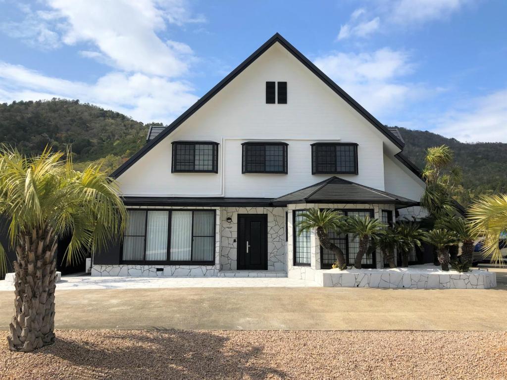 近江八幡市BIWAKO RESORT Second House的一座棕榈树掩映的白色房子