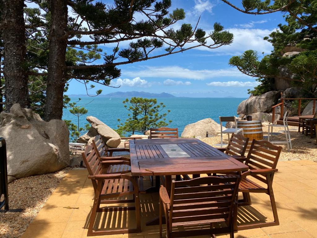 耐莉湾The Boulders - Oceanfront Couple's Retreat with private pool near ferry的一张木桌和椅子,享有海景