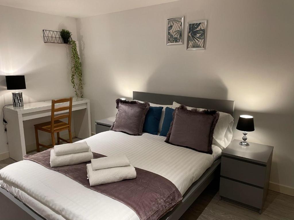 伦敦City airport serviced apartment London的一间卧室配有一张带两个枕头的床