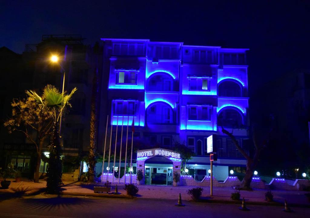 安塔利亚BODENSEE HOTEL的一座晚上有蓝色灯光的建筑