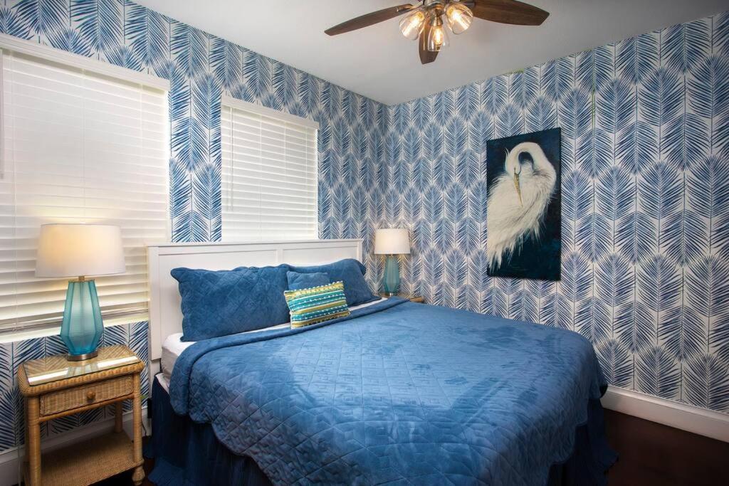 基韦斯特Duval Street Suite with pool的蓝色的卧室,配有一张床和一幅鸟画