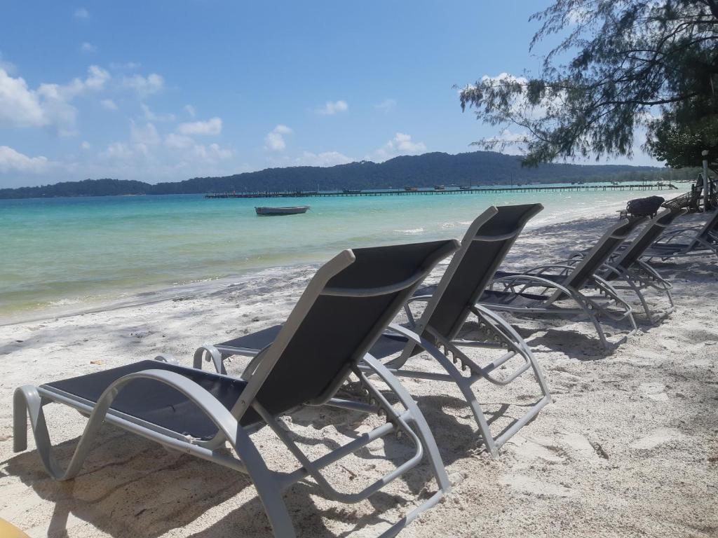 高龙撒冷岛阳光别墅旅馆的一组椅子坐在海滩上