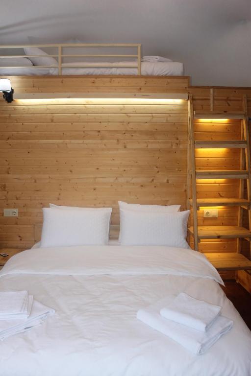 萨尔皮Glamping Village的卧室配有一张白色大床和木墙