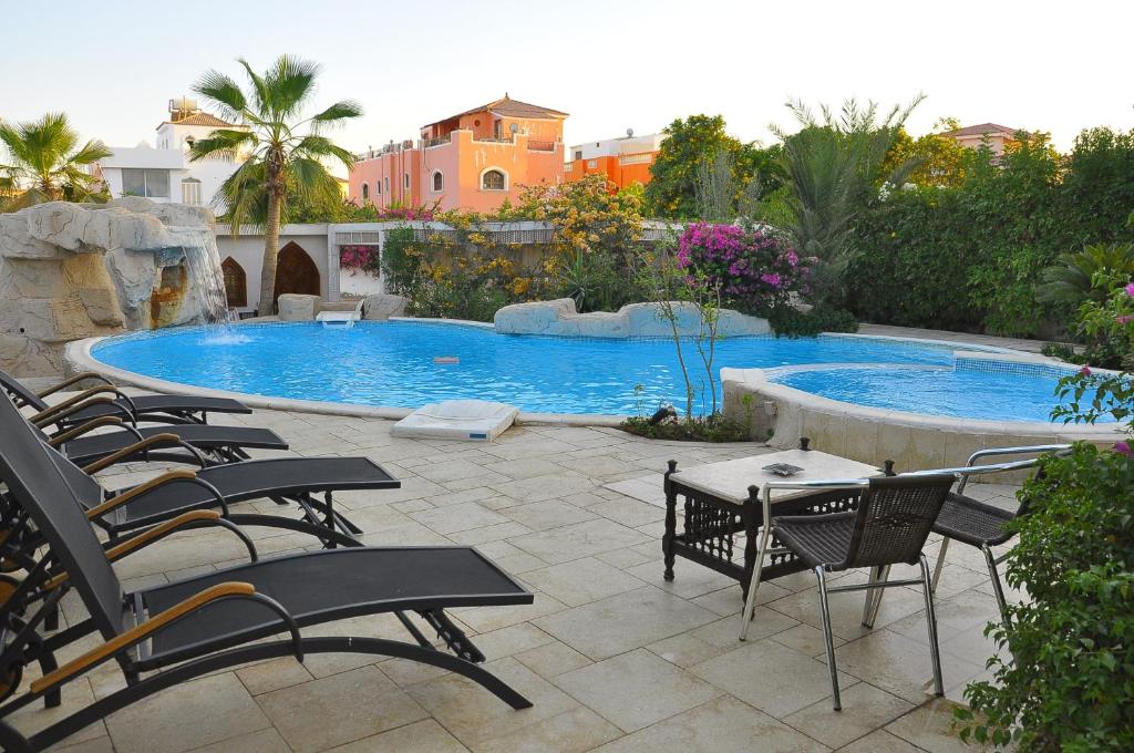 沙姆沙伊赫沙拉扎沙姆沙伊赫别墅的一个带椅子的庭院和一个游泳池