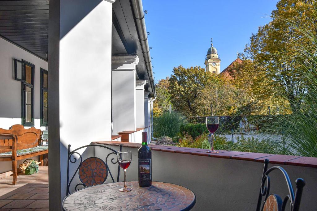 森特什Szin-es Vendeghaz的阳台上的桌子和两杯葡萄酒