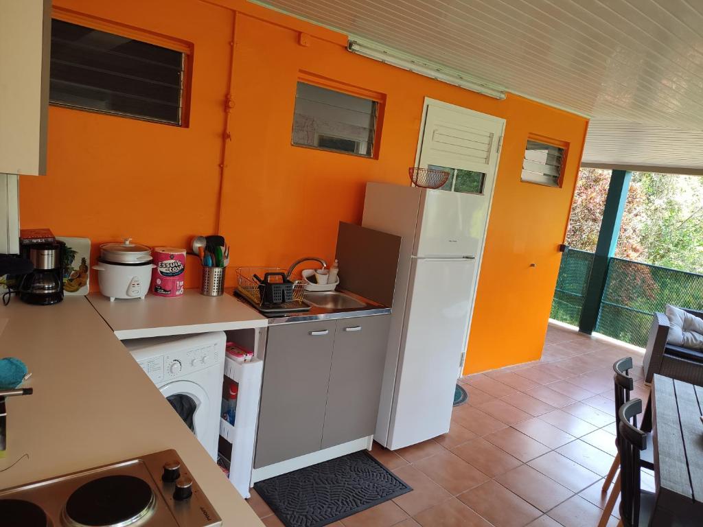 勒马兰Appartement Kelysa的厨房设有橙色墙壁和白色冰箱。