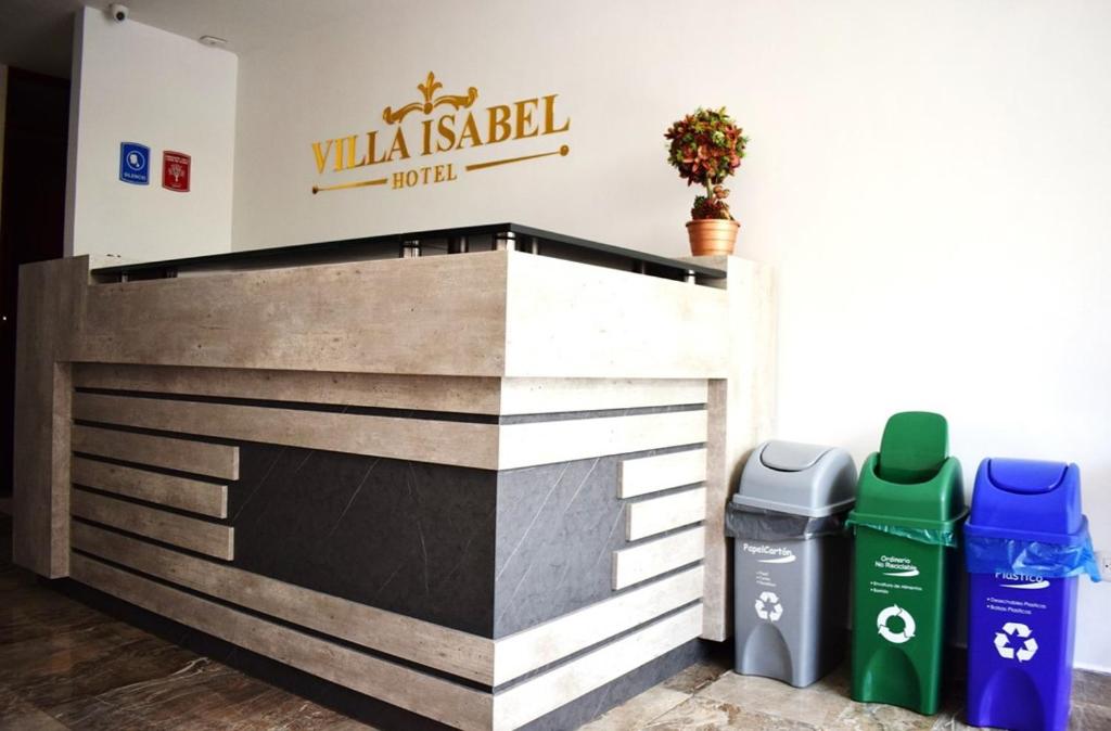 帕斯托Hotel Villa Isabel的建筑前的壁炉,有两把垃圾桶