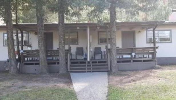 阿尔托High Country Lodge的房屋前方有两把椅子和树木