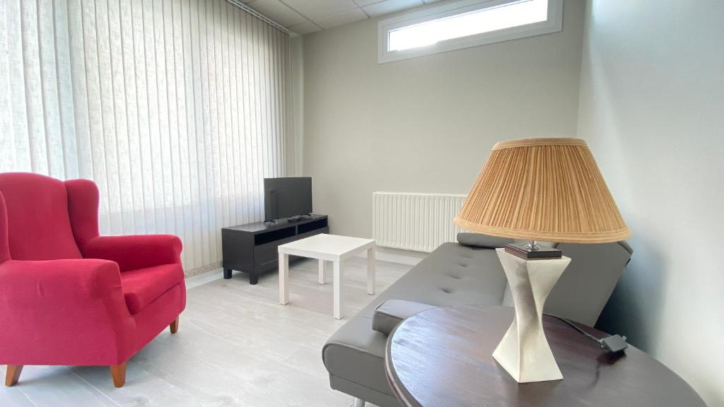 费雷拉Apartamentos Pantón Ribeira Sacra的客厅配有红色椅子和带台灯的桌子