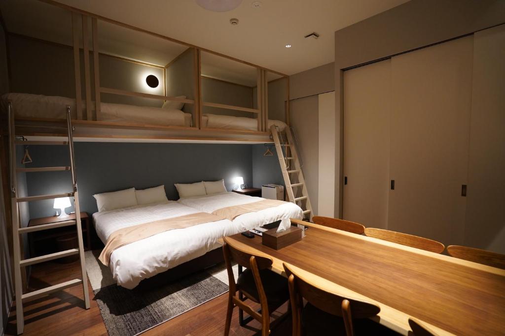 札幌Riverside Hotel Sapporo的一间卧室配有一张床、一张书桌和双层床。