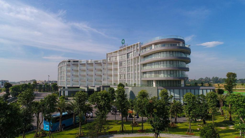 YenDIC Star Hotels & Resorts Vinh Phuc的前面有树木的大建筑