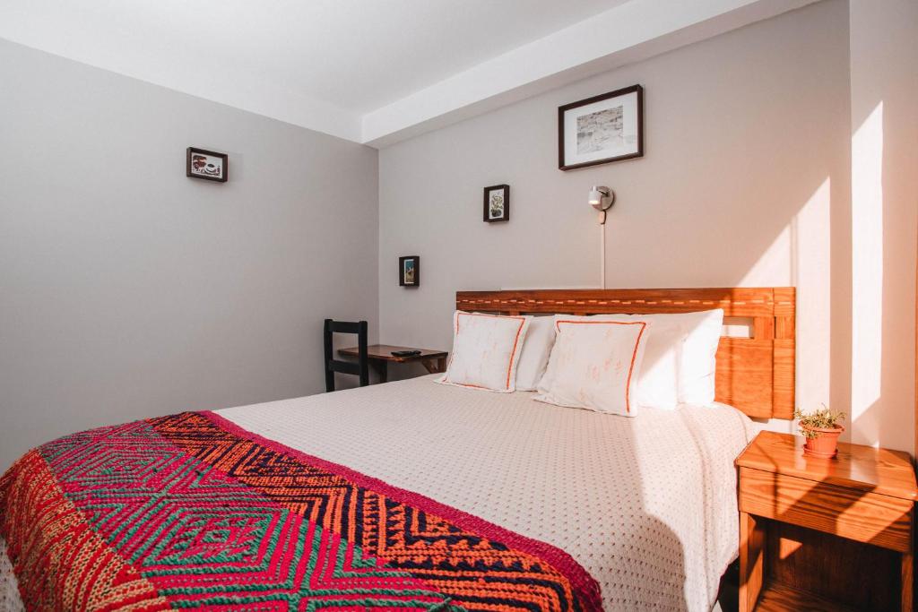 库斯科Dreams House Cusco的一间卧室配有一张带红白毯子的床