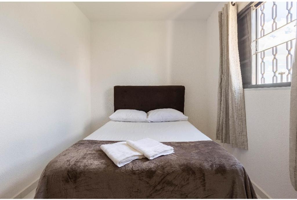 布拉干萨-保利斯塔D01 Apto com estacionamento, piscina e churrasqueira的一间卧室配有一张床,上面有两条毛巾