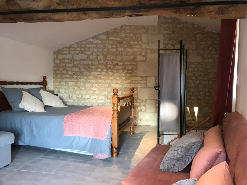 BeaumontL’Atelier de René Futuroscope的一间卧室设有一张床和砖墙