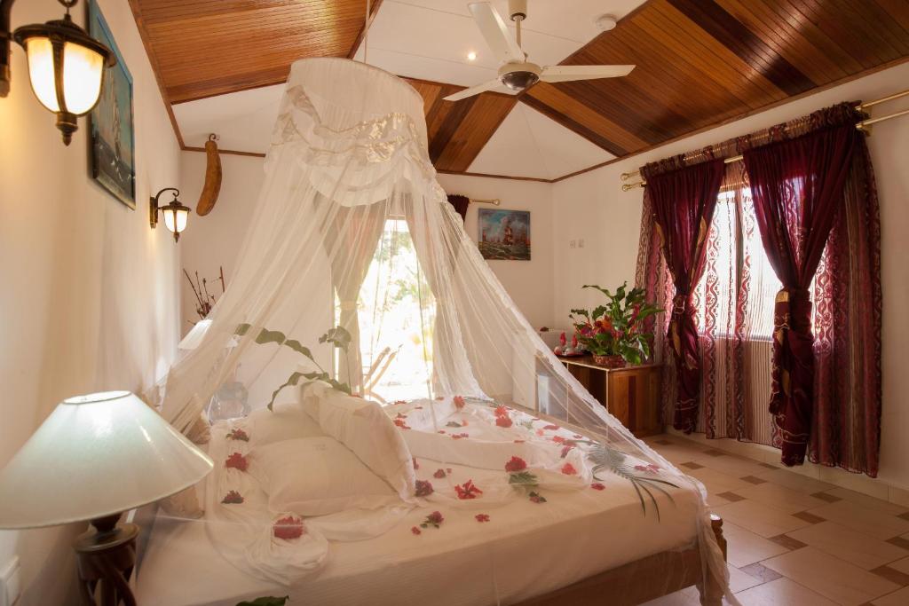 拉迪格岛Etoile Labrine Guest House的一间卧室配有一张带天蓬的白色床
