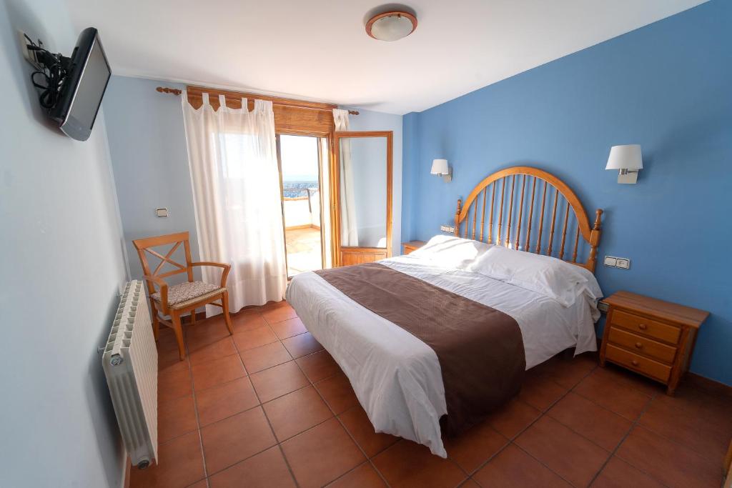 Gúdar古达尔旅馆的一间卧室配有一张蓝色墙壁的床和电视