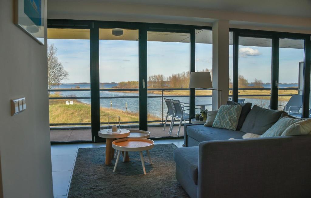 阿讷默伊登Appartement aan jachthaven met zicht op Veerse meer的带沙发的客厅,享有水景