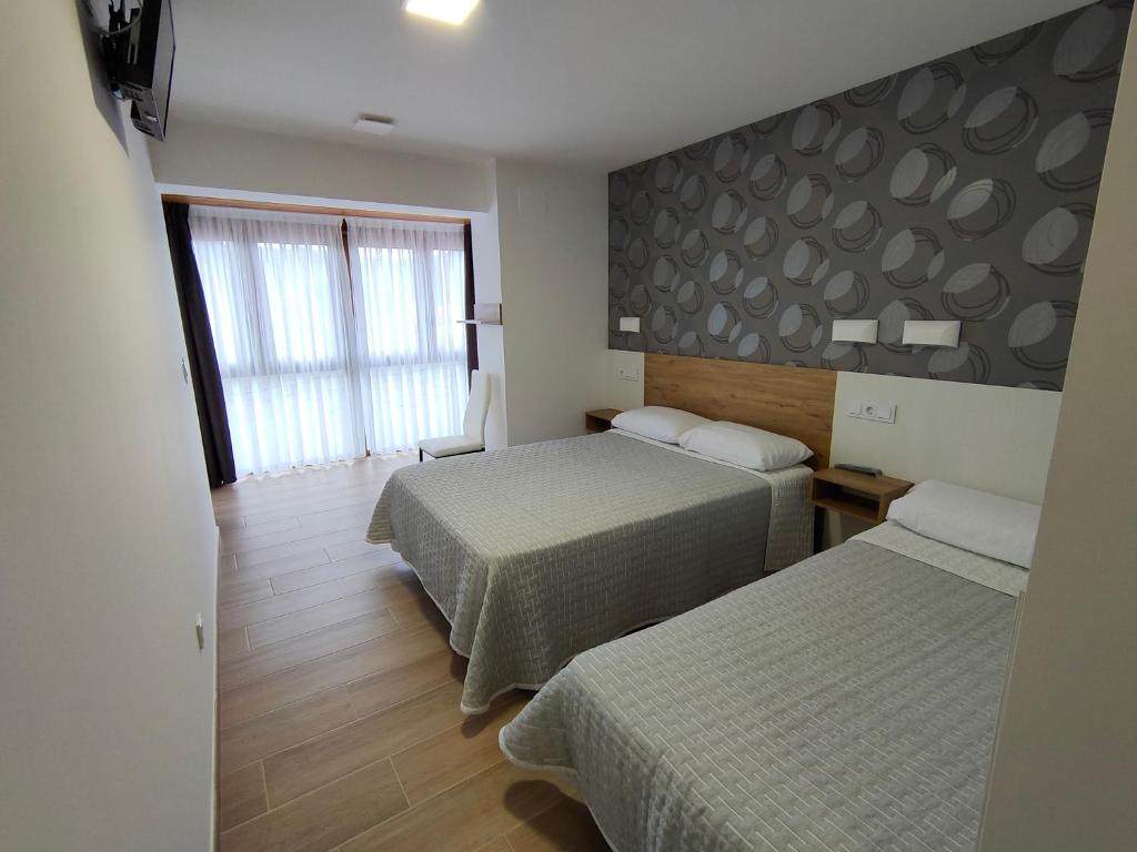 PenagosEl Pino的酒店客房设有两张床和窗户。