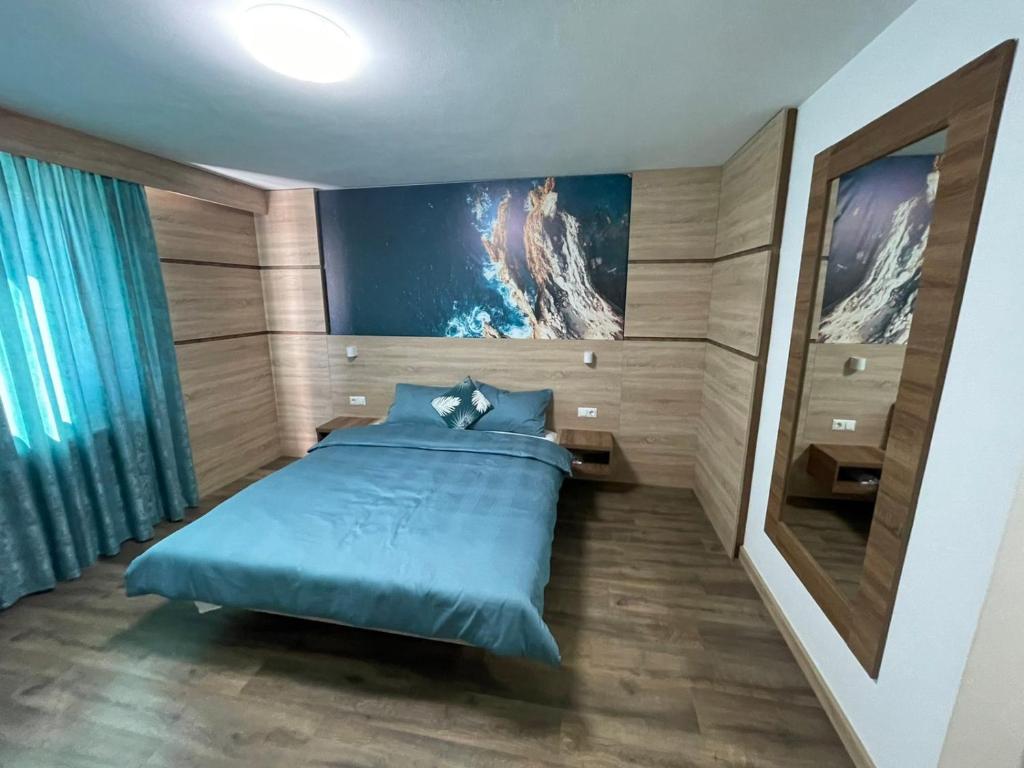察津Motel "KULA"的卧室配有蓝色的床和墙上的绘画作品