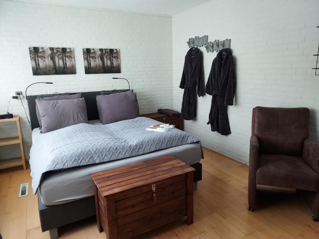 罗斯马伦B&B de Sluis的一间卧室配有一张床和一把椅子