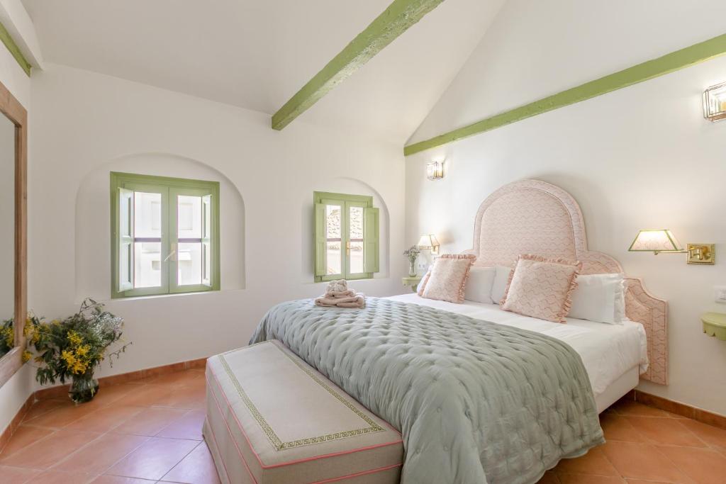 塞维利亚La Abadia de Giralda的一间卧室设有一张大床和两个窗户。