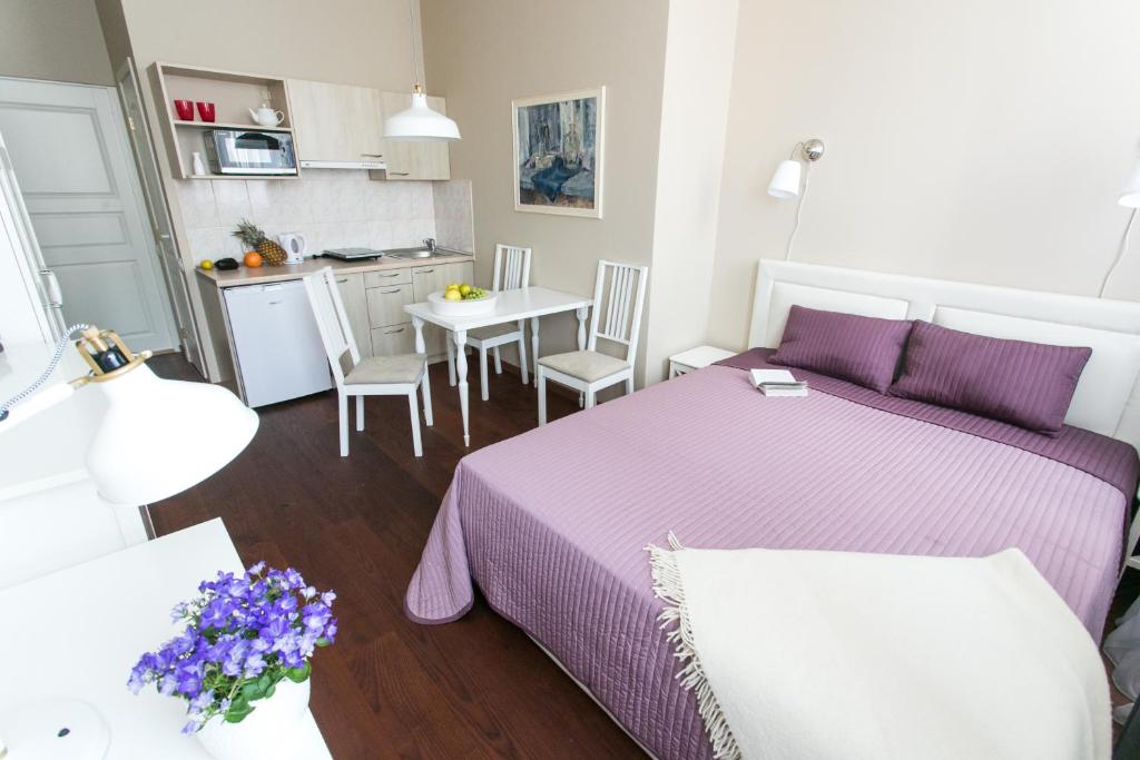 维尔纽斯格迪米纳斯公寓的一间卧室配有一张床和一张带紫色床单的桌子