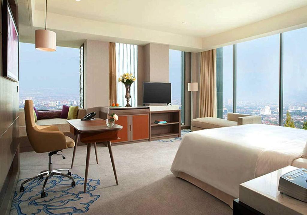 河内Golden Sun Hotel的酒店客房配有一张床、一张书桌和一台电视。