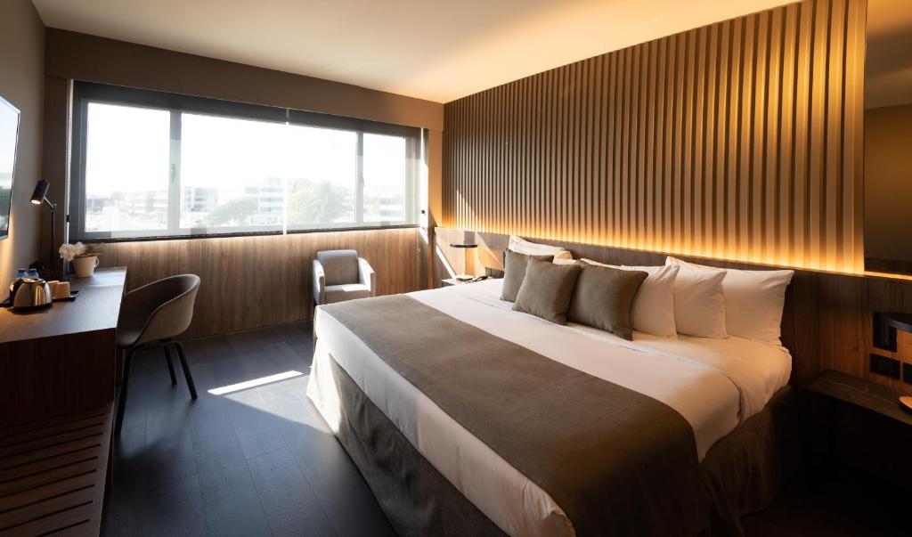 埃普拉特约布里加BAH巴塞罗那机场酒店的配有一张床、一张书桌和一扇窗户的酒店客房