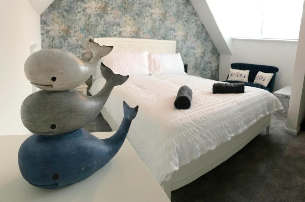 伯恩茅斯The Beach Hut - 1 Bedroom Apartment Near the Beach的卧室,床上有两只鲸的雕像