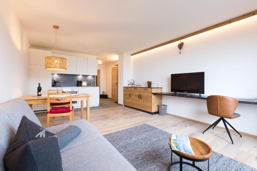 因斯布鲁克Apartment Wiesenhof - NATUR & WEITBLICK über Innsbruck - Ladestation für Elektroautos的客厅配有沙发和桌子