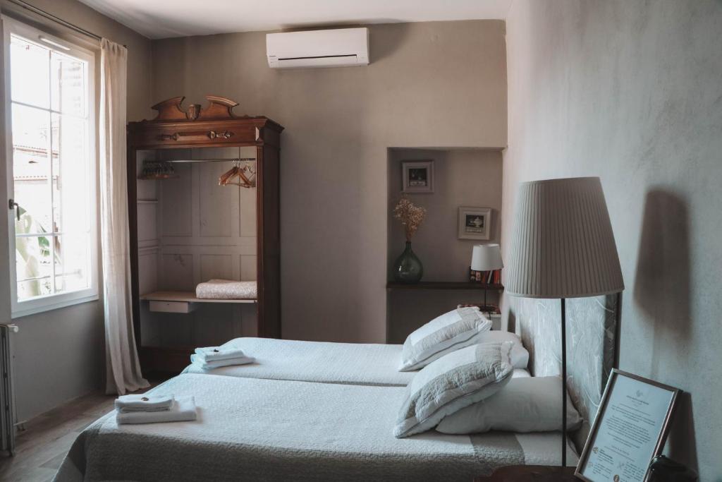 盖亚克德尔加住宿加早餐旅馆的一间卧室配有两张床、一盏灯和镜子