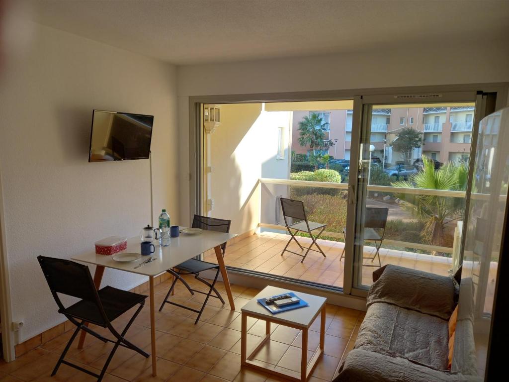 阿格德角Hélios 24, T2 climatisé, parking, terrasse, 500m plage的客厅配有沙发和桌椅