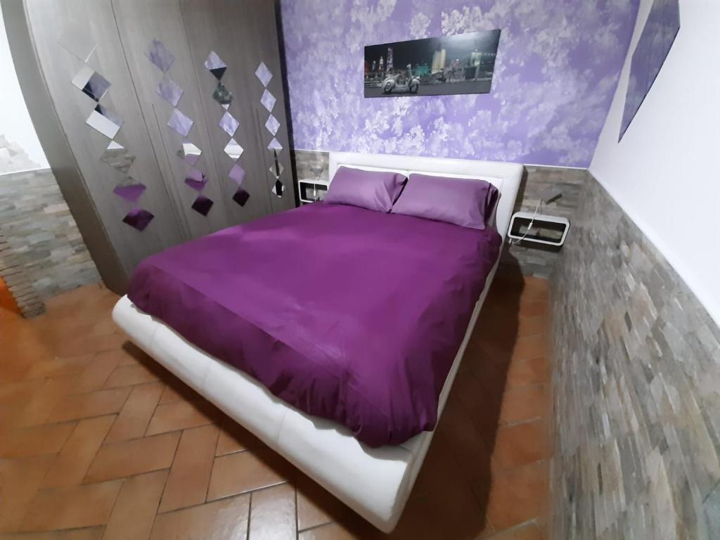 奇维塔韦基亚Al centro del porto的一间卧室配有紫色床单和紫色床