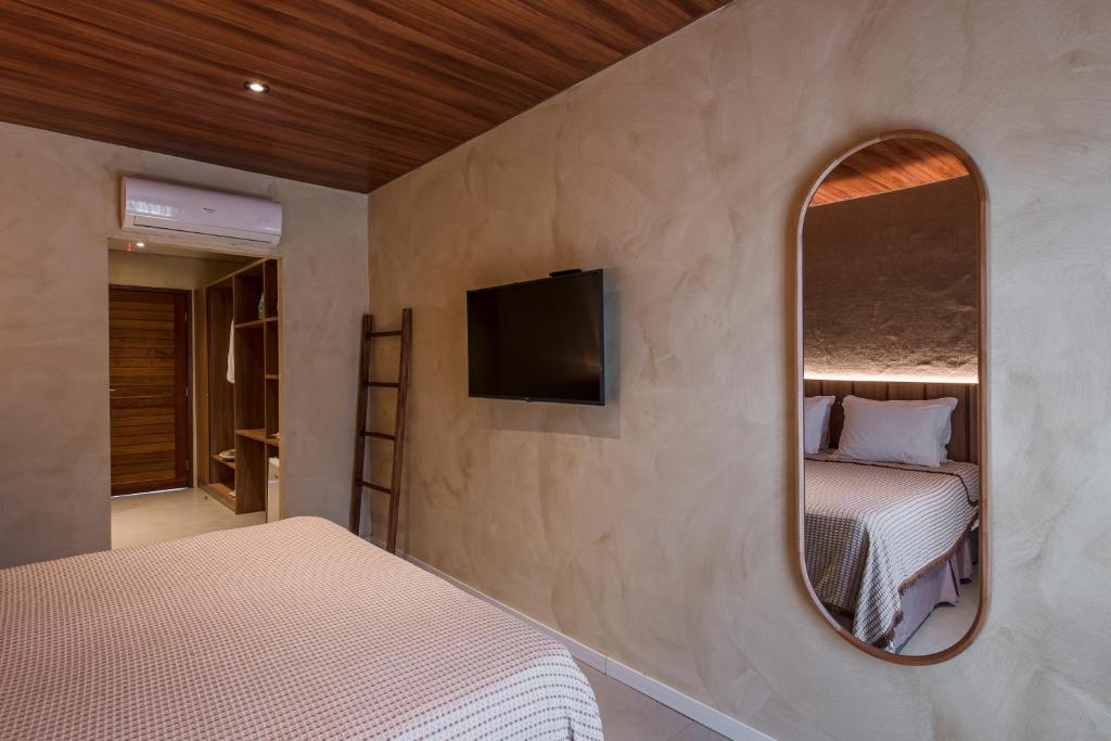 费尔南多 - 迪诺罗尼亚Vila Sal Boutique Noronha的一间卧室配有两张床和镜子